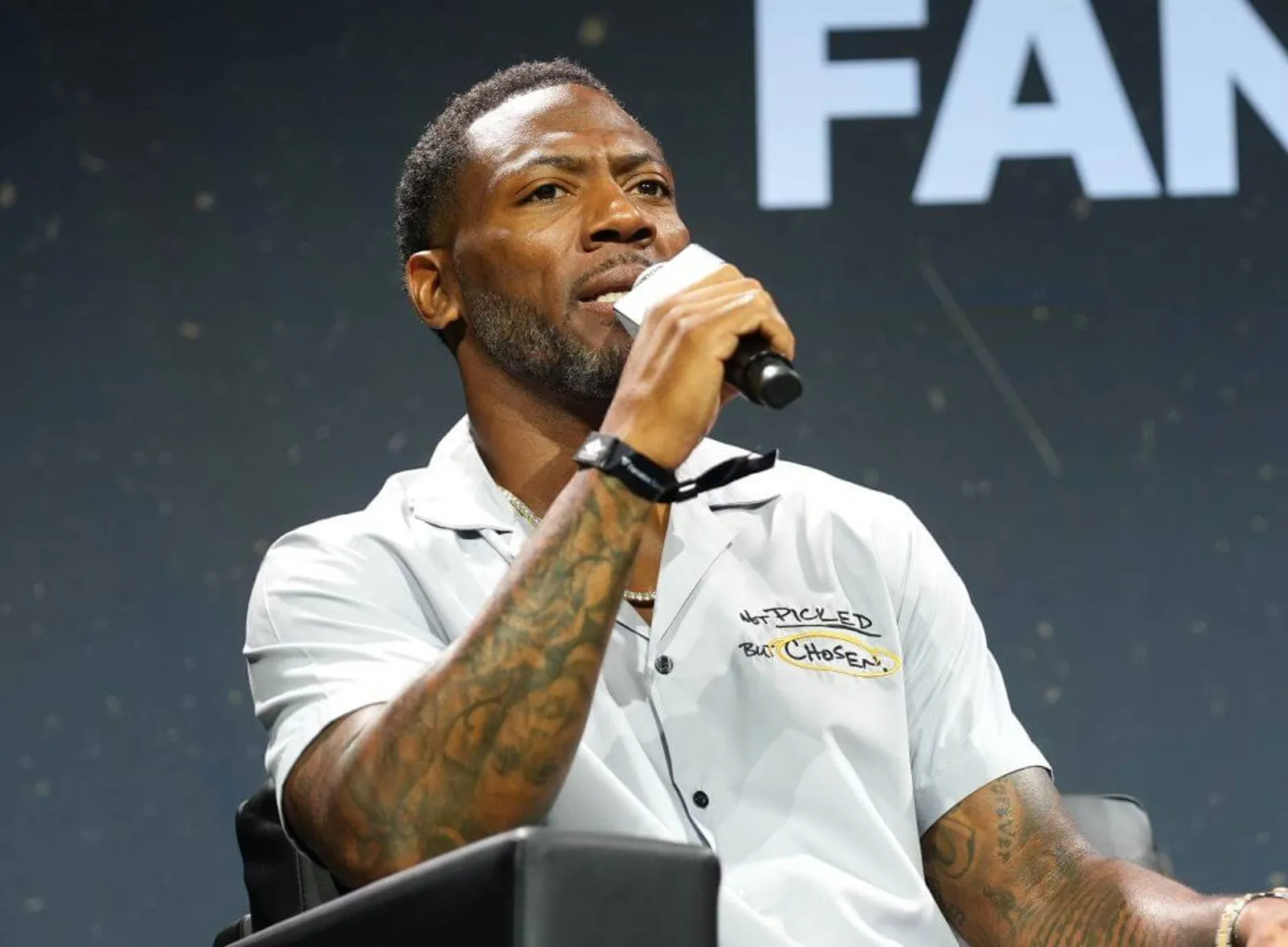 Ryan Clark is shown speaking into a microphone onstage during Fanatics Fest in New York.