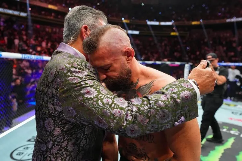Conor McGregor of Ireland is consoled by Bruce Buffer after suffering a loss against Max Holloway in a welterweight fight during the UFC 329 event at T-Mobile Arena on July 11, 2026 in Las Vegas, Nevada. (Photo by Chris Unger/Zuffa LLC)